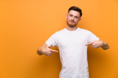 Kahverengi duvar üzerinde Redhead adam gururlu ve kendini tatmin