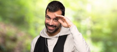 Bir parkta el ile Saluting spor adam