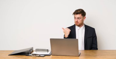 İşadamı bir ofiste mutsuz ve yan işaret