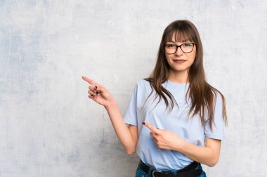 Grunge arka plan işaret parmağı yanında genç kadın