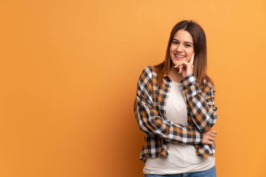 Genç kadın üzerinde kahverengi duvar düşünmek bir fikir süre seyir yukarı