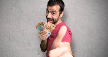 Adam bir şey iyi dokulu duvar üzerinde oldu çünkü jest kadar başparmak vererek çok para alıyor