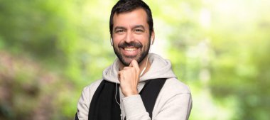 Spor adam bir parkta tatlı bir ifade ile gülümsüyor