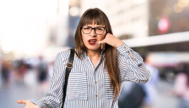 Gözlük ile kadın telefon jest yapma ve açık havada şüphe