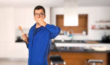 Evde uygunsuz bir şey söylemek için elleri ile ağız kapsayan ressam adam