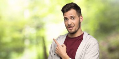 Sweatshirt ile adam sürpriz ve bir parkta yan işaret