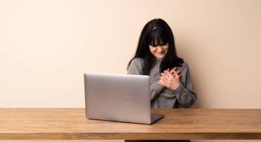 Laptopuyla çalışan genç bir kadın. Kalbinde ağrı var.