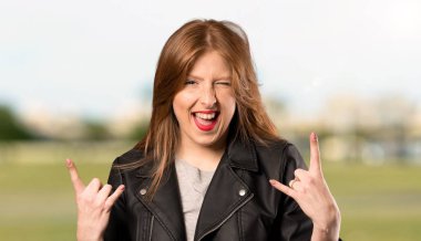 Genç Redhead kadın açık havada rock jest yapma