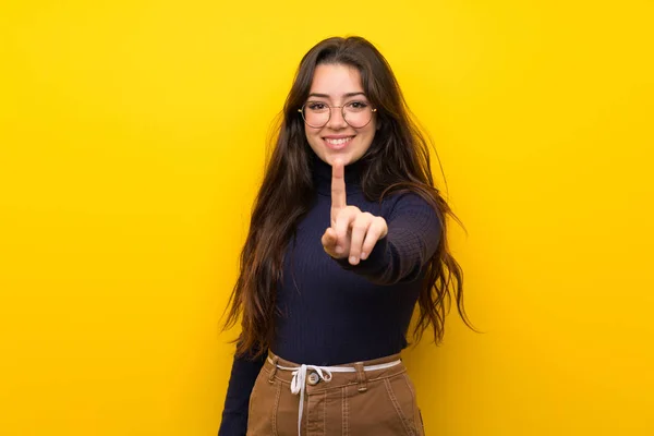 Tiener Meisje Geïsoleerde Gele Muur Zien Tillen Van Een Vinger — Stockfoto