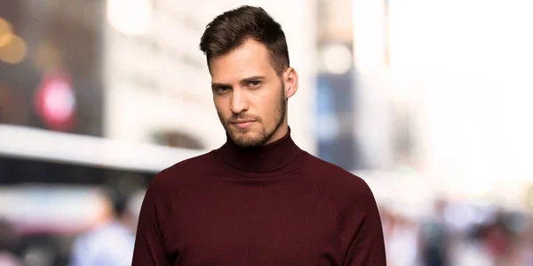 Man with turtleneck sweater with sad and depressed expression in the city