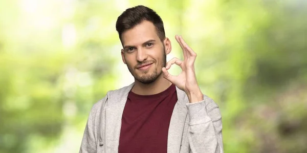 Hombre Con Sudadera Mostrando Signo Con Los Dedos Parque — Foto de Stock