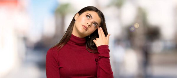 Teenager girl with turtleneck with problems making suicide gesture at outdoors