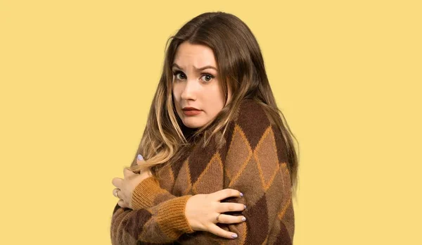 Chica Adolescente Con Suéter Marrón Congelándose Sobre Fondo Amarillo Aislado —  Fotos de Stock