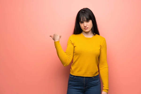 Vrouw Met Gele Trui Roze Muur Ongelukkig Wijzend Naar Zijkant — Stockfoto