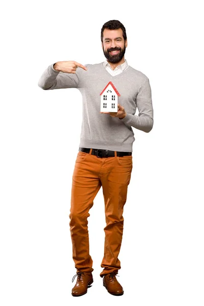 Un bel homme barbu tenant une petite maison — Photo