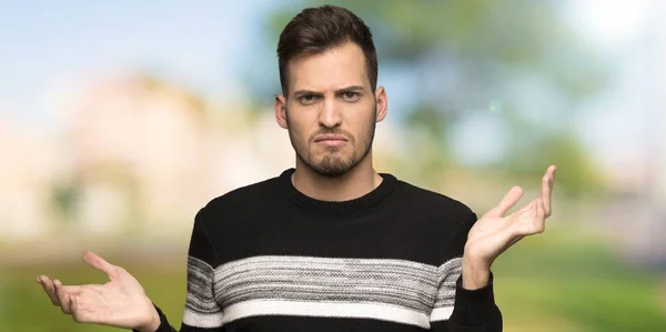 Handsome man unhappy because not understand something at outdoors