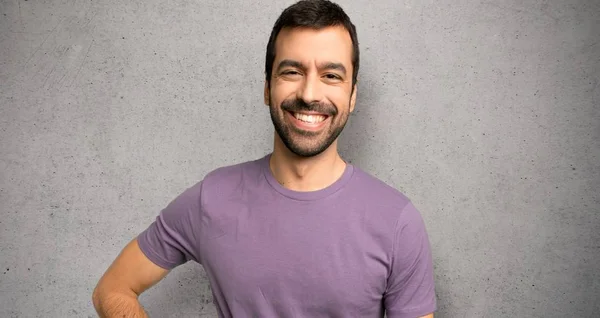 Handsome Man Posing Arms Hip Smiling Textured Wall — Stock Photo, Image