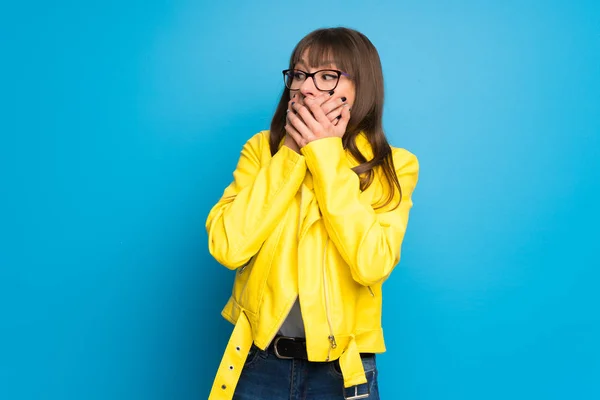 Young Woman Yellow Jacket Blue Background Covering Mouth Hands — Stock Photo, Image