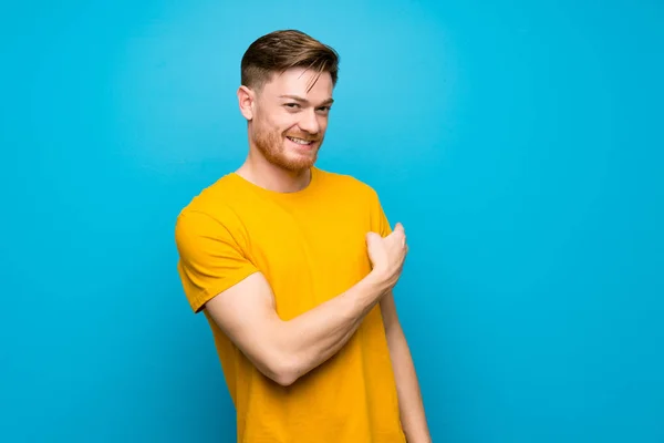 Mavi Duvarın Üzerinde Redhead Adam Geri Işaret — Stok fotoğraf