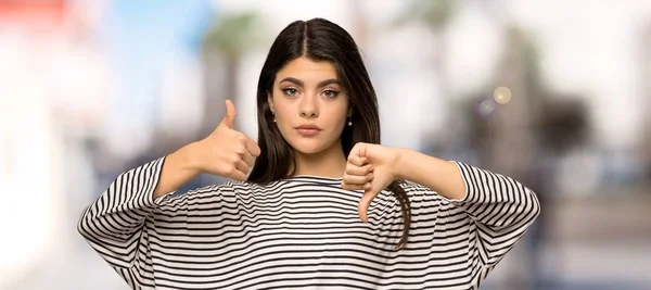 Menina Adolescente Com Camisa Listrada Fazendo Bom Mau Sinal Indecisos — Fotografia de Stock