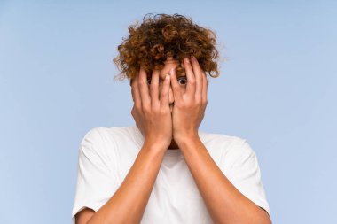 Beyaz gömlekli, gözlerini kapayan ve parmaklarından içeri bakan Afrikalı genç bir Amerikalı.