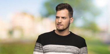 Açık havada ısırık dudak iken yüz ifadesi karıştırır ile yakışıklı adam