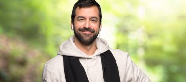 Spor adam kalça ve bir parkta gülümseyen silah ile poz