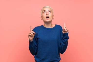 Pembe duvar üzerinde beyaz kısa saçlı genç kız şaşırttı ve işaret