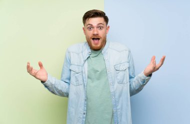 Şok yüz ifadesi ile renkli arka plan üzerinde Redhead adam