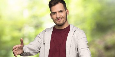 Sweatshirt sunan ve bir parkta el ile gelmek için davet ile adam