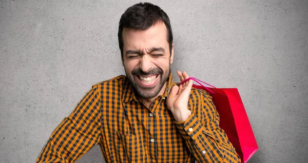 Hombre Con Bolsas Compras Feliz Sonriente Sobre Pared Texturizada —  Fotos de Stock