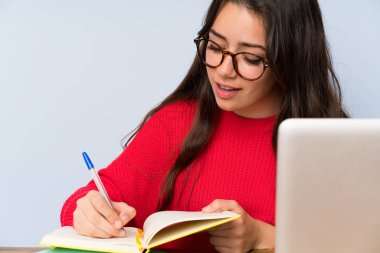 Bir masada okuyan genç öğrenci kız