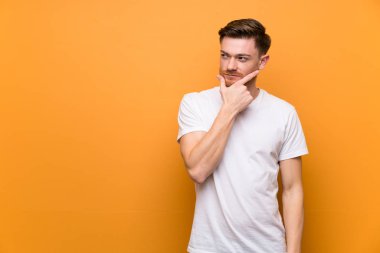 Kahverengi duvar üzerinde Redhead adam düşünme