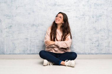 Gülümseyerek bir masada okuyan genç öğrenci kız yukarı bakıyor