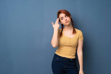 Mavi arka plan ile intihar jest yaparken sorunlarla genç Kızıl saçlı kadın