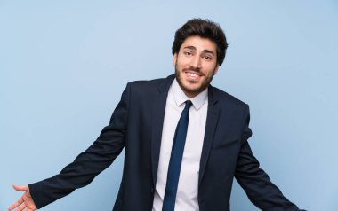 İzole mavi duvar üzerinde işadamı gülümseyerek