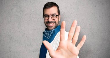 Beş parmak ile dokulu duvar'ın üstüne sayma gözlüklü yakışıklı adam