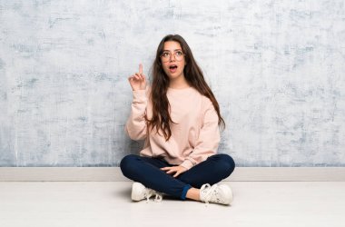 Bir masada okuyan genç öğrenci kız bir fikir parmağını işaret düşünme