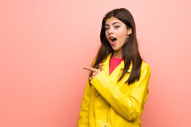 Pembe duvar üzerinde genç kız şaşırttı ve yan işaret