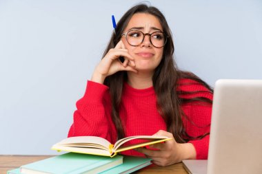 Bir masada okuyan sinirli genç öğrenci kız
