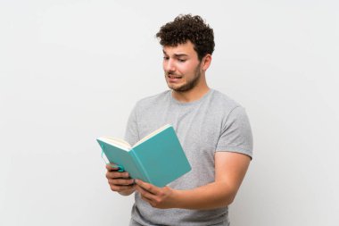 İzole duvar üzerinde kıvırcık saçlı adam tutan ve bir kitap okuma