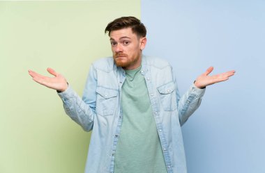 Rengarenk arka plan üzerinde Redhead adam şüpheler jest yapma