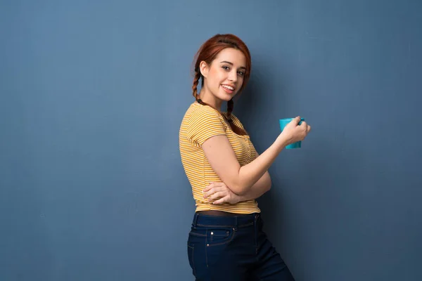 Young Redhead Woman Blue Background Holding Hot Cup Coffee — Stock Photo, Image