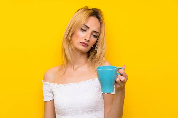 Junge Blonde Frau Über Isolierte Gelbe Wand Mit Heißer Tasse — Stockfoto