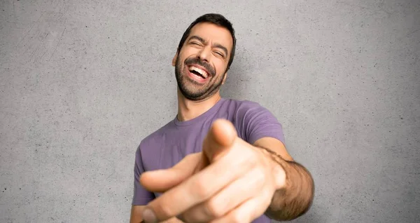 Yakışıklı Adam Birini Parmakla Işaret Dokulu Duvar Üzerinde Çok Gülüyor — Stok fotoğraf