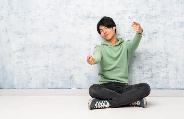 Asiatischer Mann Der Auf Dem Boden Sitzt Zeigt Lächelnd Mit — Stockfoto