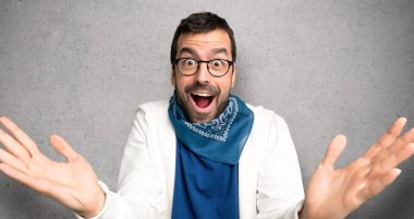 Sürpriz ve dokulu duvar üzerinde şok yüz ifadesi ile gözlüklü yakışıklı adam