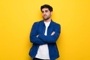 Sarı duvar portresi üzerinde mavi ceketli adam