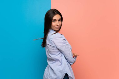 Pembe ve mavi duvarın üzerinden genç kadın