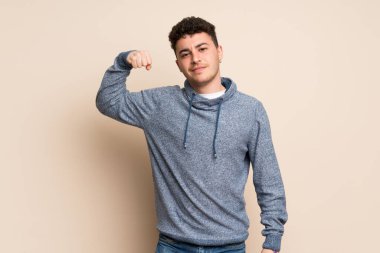 Duvarı aşan genç adam güçlü bir hareket yapıyor.